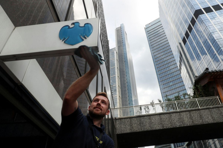 A worker cleans a Barclays logo outside a bank branch in the financial district of London, Britain July 8, 2019.