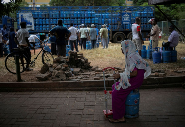 A woman sits on an empty domestic cooking gas cylinder at a distribution centre, amid the country's economic crisis, in Colombo, Sri Lanka, July 23, 2022.