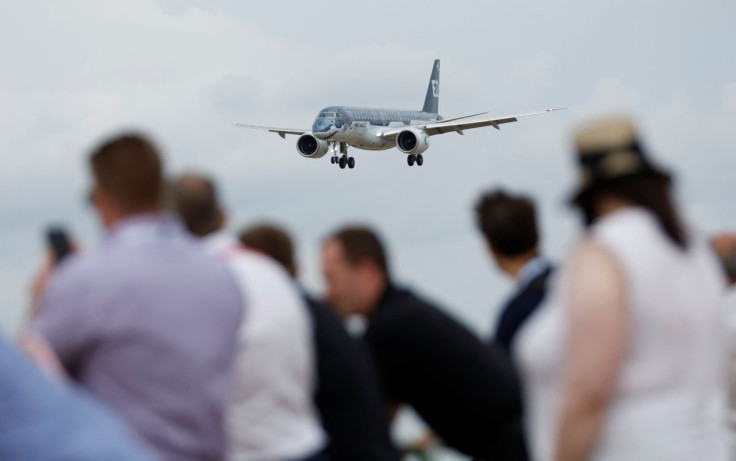 Attendees watch a Embraer 190 aircraft during a display at the Farnborough International Airshow, in Farnborough, Britain, July 20, 2022.