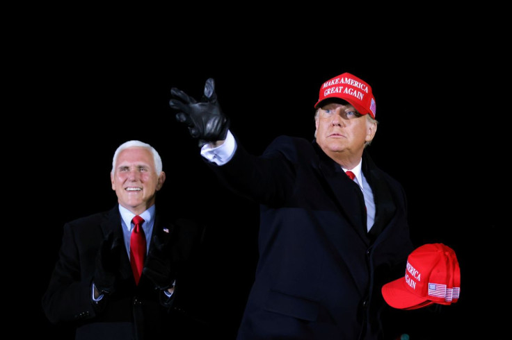 U.S. President Donald Trump hands out caps to supporters next to Vice President Mike Pence, as he holds a campaign rally at Gerald R. Ford International Airport in Grand Rapids, Michigan, U.S., November 2, 2020.