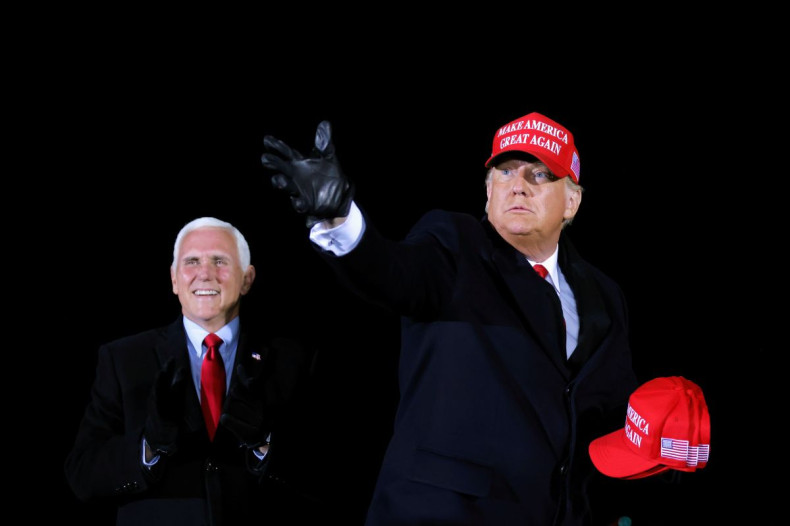 U.S. President Donald Trump hands out caps to supporters next to Vice President Mike Pence, as he holds a campaign rally at Gerald R. Ford International Airport in Grand Rapids, Michigan, U.S., November 2, 2020. 