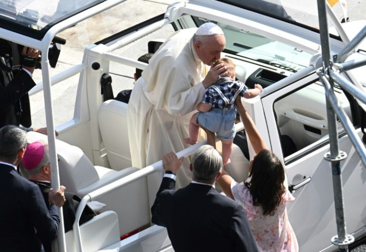 Pope Francis kisses a child as he arrives for an open-air mass in Edmonton, Canada, on July 26, 2022