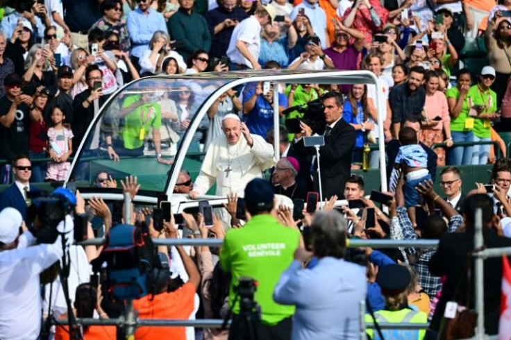 Pope Francis waved and smiled as he made his way in the popemobile through the venue in Edmonton, Alberta, for an open-air mass