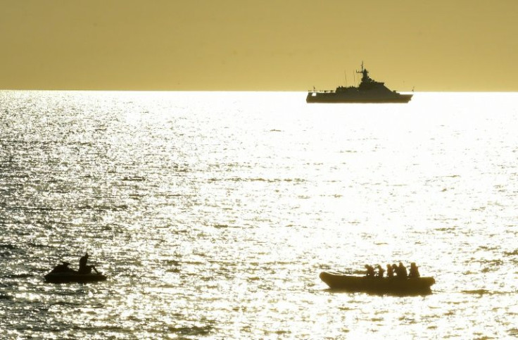 In Sevastopol, Crimea's largest city and home to the Russian Black Sea fleet, Russian warships are visible as beachgoers cool off in the seaÂ 