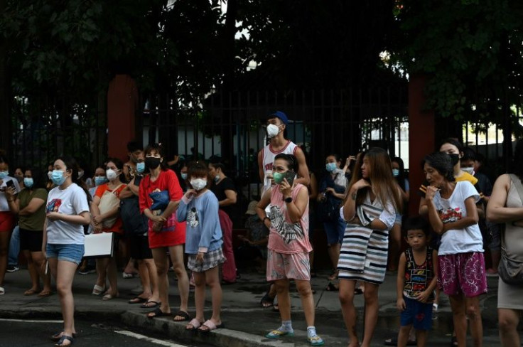 Residents of buildings in Manila stand outside after a 7.1 magnitude earthquake some 300 kilometers away was felt in Manila