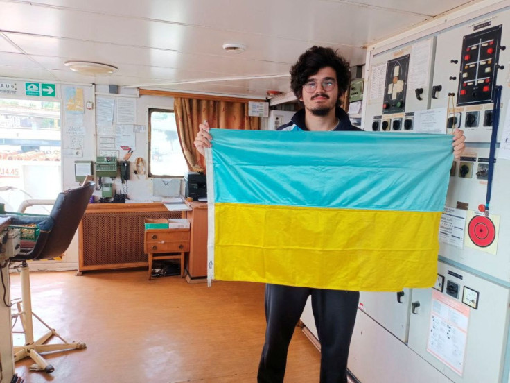 Burak Kinayer, a 19-year-old deck cadet of the Turkish-flagged cargo ship Kaptan Cevdet, poses with a Ukrainian flag aboard his ship in Odesa, Ukraine July 27, 2022. Courtesy of Burak Kinayer/Handout via REUTERS 