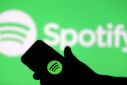 A smartphone is seen in front of a screen projection of the Spotify logo in this picture illustration taken April 1, 2018. 