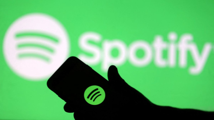 A smartphone is seen in front of a screen projection of the Spotify logo in this picture illustration taken April 1, 2018. 