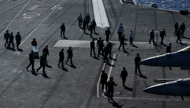 Crew members work on the deck of the USS Ronald Reagan in the South China Sea September 30, 2017. 