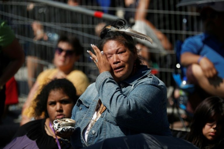 An Indigenous woman cries as Catholic faithful listen to Pope Francis celebrate mass inside the shrine of Sainte-Anne-de-Beaupre in Quebec, Canada