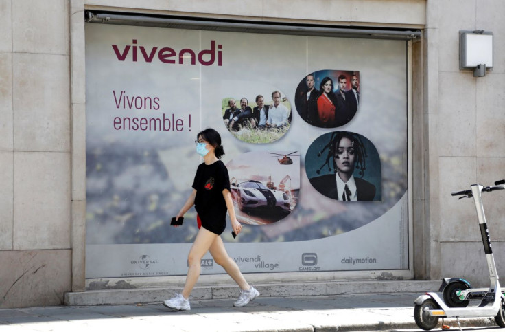  A woman walks past signage of French media giant Vivendi at the entertainment-to-telecoms conglomerate headquarters in Paris, France, August 12, 2020.    