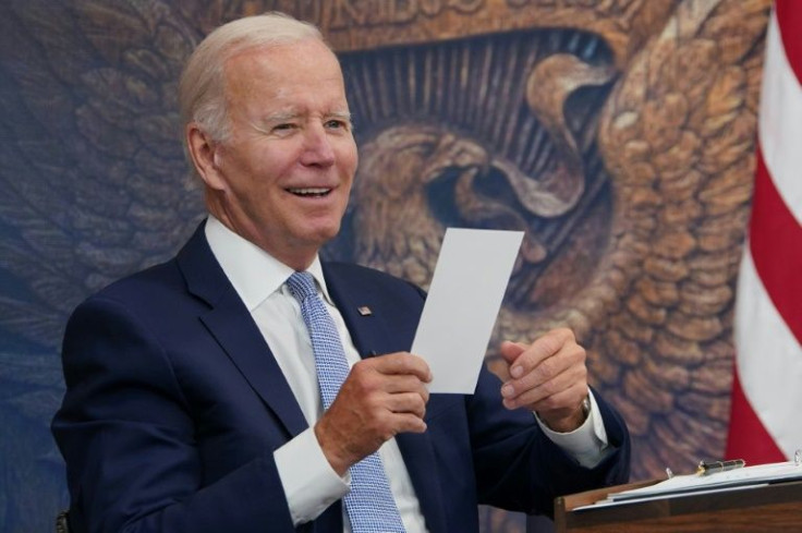 US President Joe Biden reacts to a note given to him saying that a bill to boost domestic semiconductor production has passed the House of Representatives