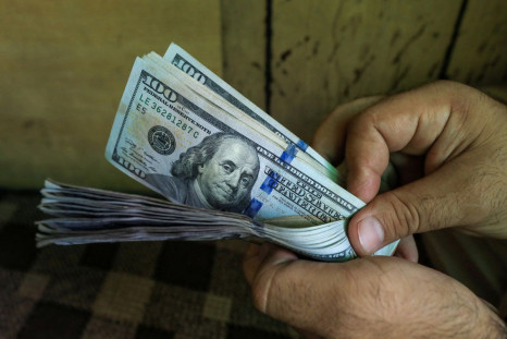 A trader counts U.S. dollar banknotes at a currency exchange booth in Peshawar, Pakistan September 15, 2021. 