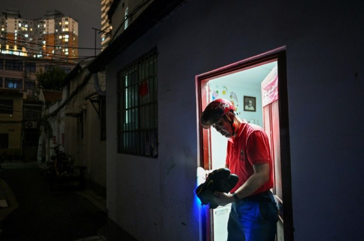 A resident of Shanghai's Laoximen neighbourhood disinfects his shoes before entering his home, which is scheduled for demolition