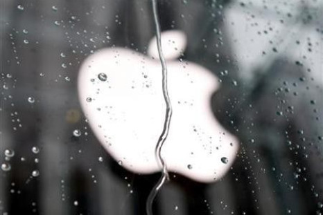 The Apple logo is seen through raindrops on a window outside of the New York City flagship Apple store