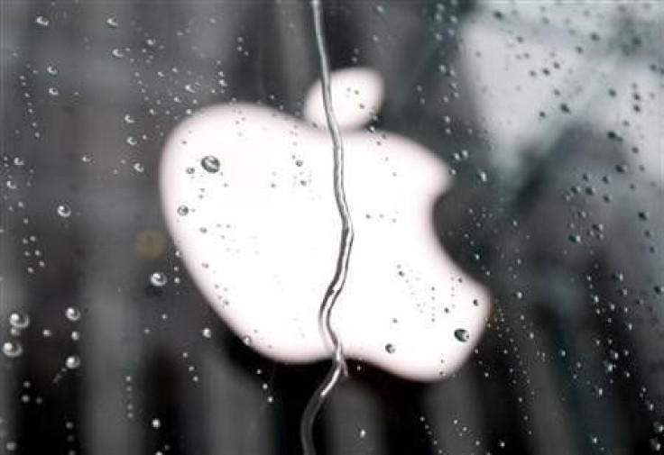 The Apple logo is seen through raindrops on a window outside of the New York City flagship Apple store
