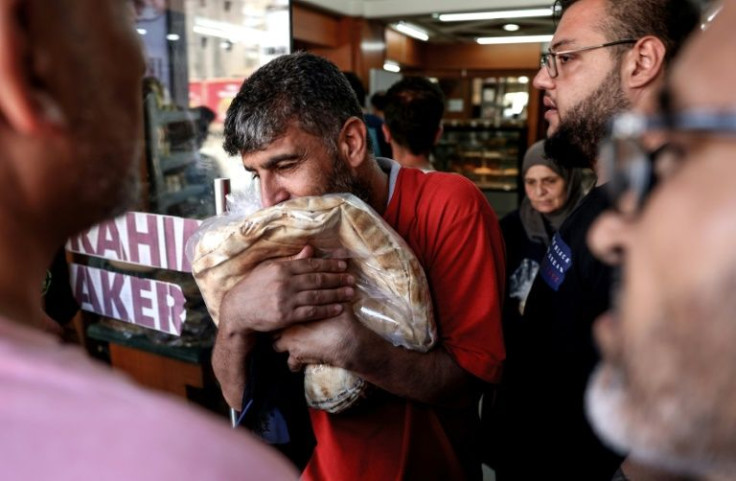 A customer clutches a bag of subsidised flatbread after finally reaching the front of the queue at a a bakery in the Lebanese capital Beirut