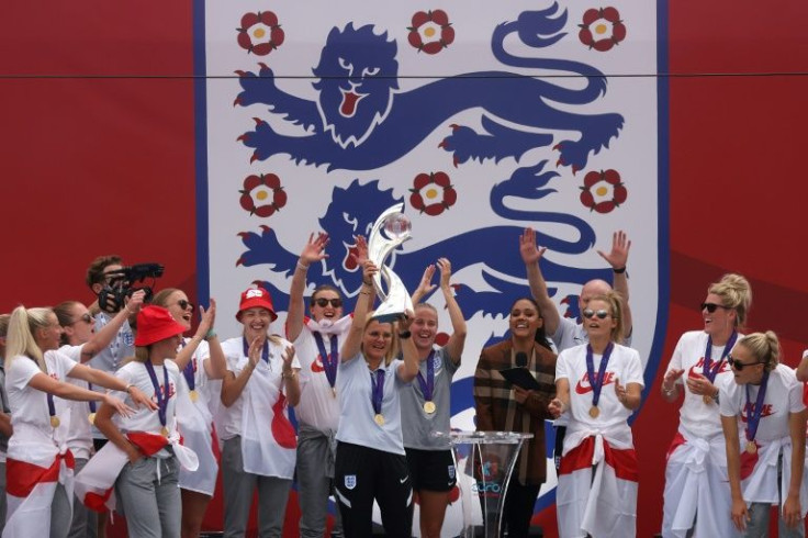England coach Sarina Wiegman lifts the European trophy alongside her players in Trafalgar Square