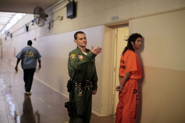 An inmate is led by a prison guard at the California Institution for Men state prison in Chino