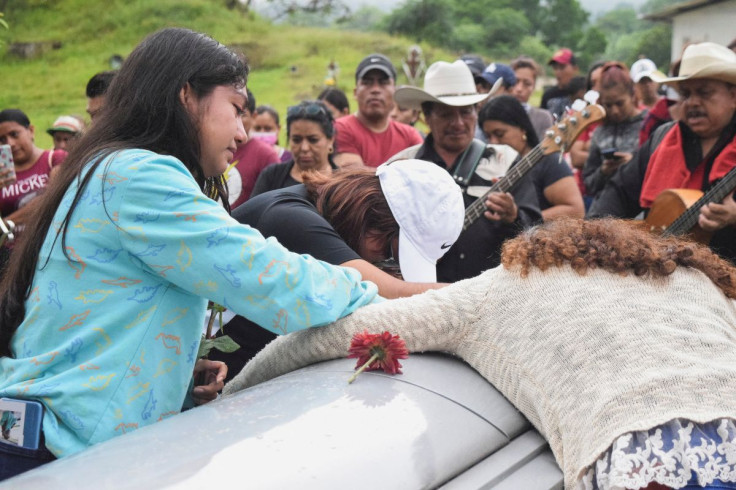 Relatives of late migrant Pablo Ortega Alvarez, who died due to suffocation while being smuggled in a trailer in San Antonio, Texas, U.S., mourn over his casket during his burial at the local cemetery, in the town of Tlapacoyan, in Veracruz state, Mexico,