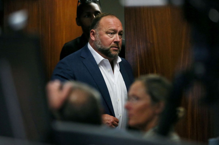Alex Jones walks into the courtroom in front of Scarlett Lewis and Neil Heslin, the parents of 6-year-old Sand Hook shooting victim Jesse Lewis, at the Travis County Courthouse in Austin, Texas, U.S. July 28, 2022. Jones had been found to have defamed the