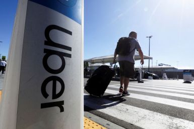 A passenger walks near Uber signage after arriving at Los Angeles International Airport (LAX) in Los Angeles, California, U.S. July 10, 2022.  