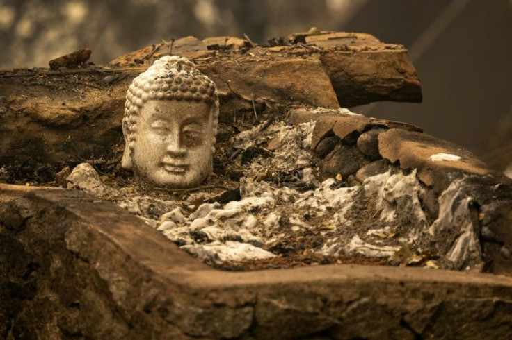A burned statue lies in the ruins of a home in the community of Klamath River in northern California
