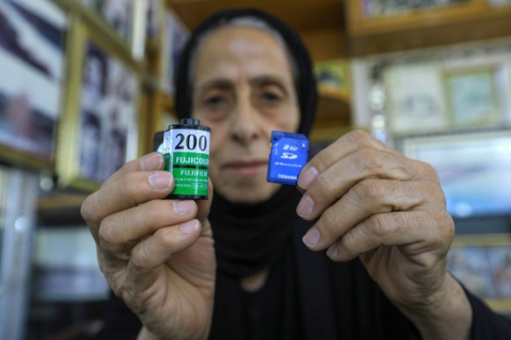 Samira Mazaal shows a film roll and a digital memory card: now aged 77, she has been working as a photographer since she was 16