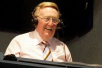 Los Angeles Dodgers announcer Vin Scully smiles in a broadcast booth during the National League MLB baseball game between the San Francisco Giants and the Los Angeles Dodgers in Los Angeles, April 25, 2007. 