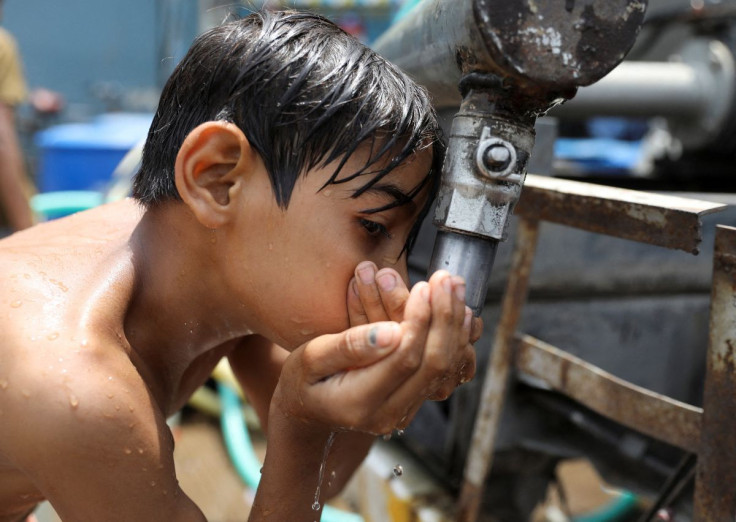 A boy drinks water from a municipal tanker on a hot summer day in New Delhi, India, May 1, 2022.