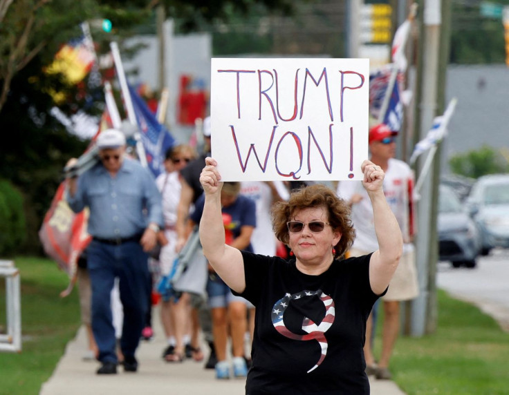 A supporter of former U.S. President Donald Trump wears a QAnon shirt while holding a sign stating he won the 2020 election, outside the North Carolina GOP convention in Greenville, North Carolina, U.S. June 5, 2021.  