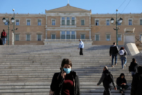 People wearing protective face masks make their way on Syntagma square after the Greek government imposed mandatory COVID vaccinations for people aged 60 and over, in Athens, Greece, December 1, 2021. 
