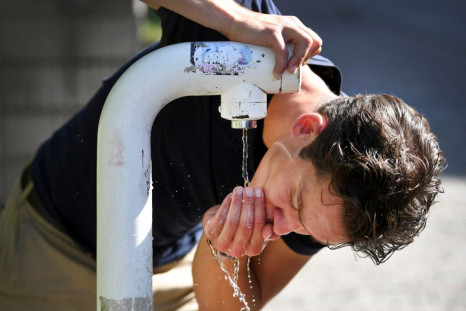 A man drinks water from a public drinking establishment during a heatwave in Nijmegen, Netherlands July 18, 2022. 