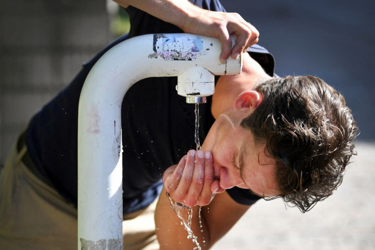 A man drinks water from a public drinking establishment during a heatwave in Nijmegen, Netherlands July 18, 2022.