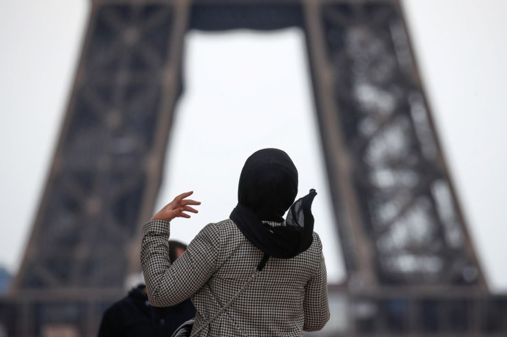 A woman wearing a hijab walks at Trocadero square near the Eiffel Tower in Paris, France, May 2, 2021. 