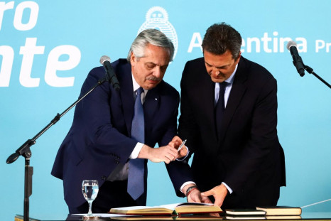 Sergio Massa, newly sworn-in as Argentina's new economy minister, signs documents next to Argentina's President Alberto Fernandez at the Casa Rosada presidential palace in Buenos Aires, Argentina, August 3, 2022. 