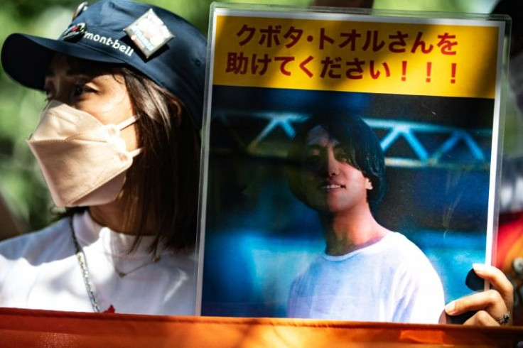 An activist in Tokyo holds a placard of Japanese journalist Toru Kubota, who is detained in Myanmar