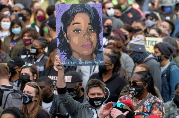 A protester holds a portrait of Breonna Taylor during a rally in Louisville, Kentucky