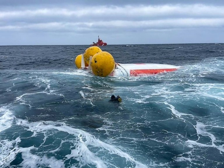 A rescue diver approaches the capsized French-flagged Jeanne Solo Sailor sailboat off Spain's northwestern region of Galicia