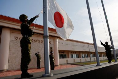 Members of the Japan Ground Self-Defense Force (JGSDF) bring down the Japanese national flag in the early evening, at JGSDF Miyako camp on Miyako Island, Okinawa prefecture, Japan April 20, 2022. 