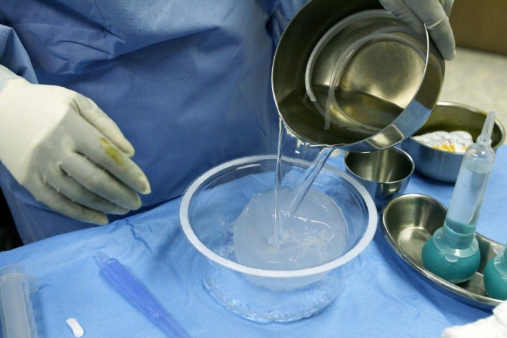 Surgical technician Vanerie Clark rinses a silicon implant prior to deflation and insertion during a breast augmentation surgery at the Plastic Surgery Center in Shrewsbury, New Jersey