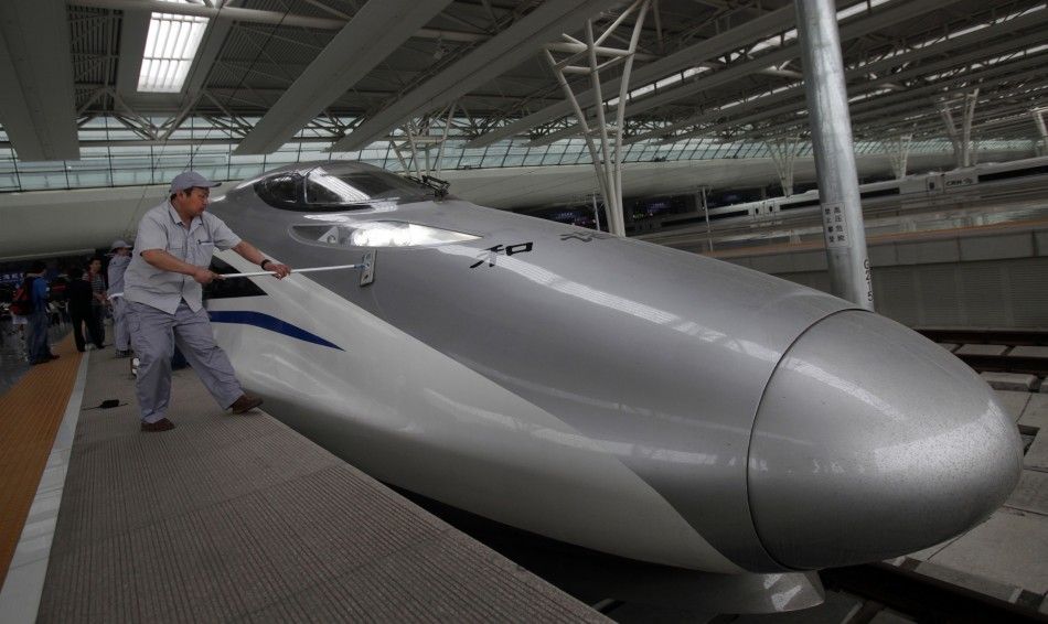 Workers clean the exterior of a CRH 380A bullet train serving the newly built high-speed railway between Shanghai and Beijing during its debut test at the Hongqiao Railway Station in Shanghai