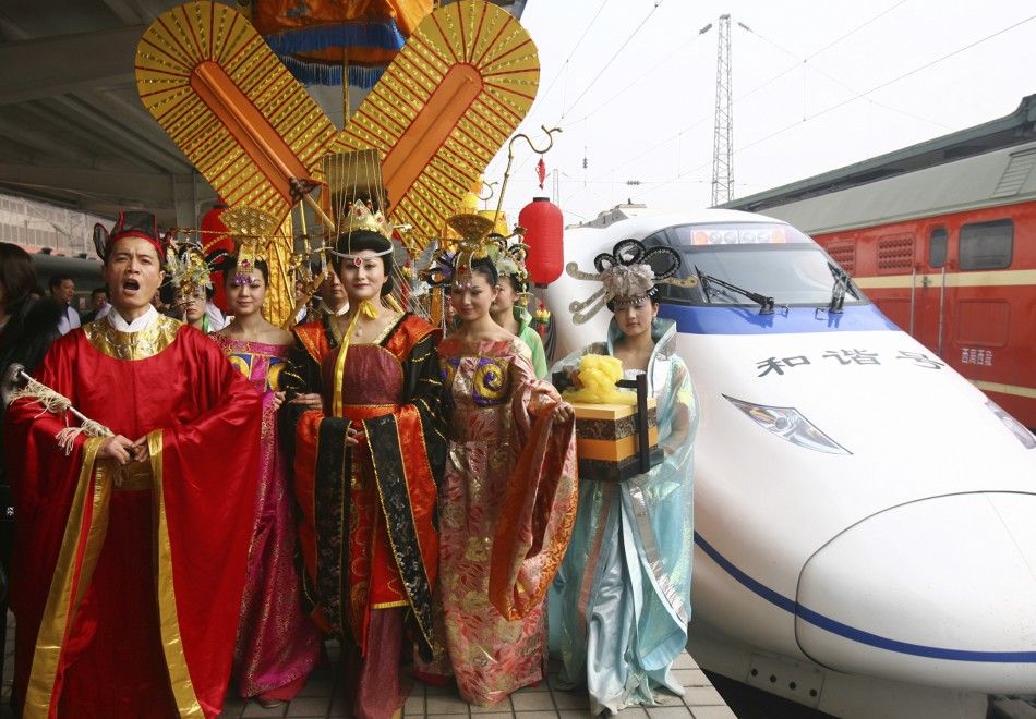 Actress dressed as China039s first female emperor Wu Zetian and her entourage walk after their ride on the maiden journey of a high-speed train from Zhengzhou to Xi039an, Shaanxi province, to celebrate the start of the train service.
