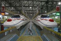 A labourer cleans the floor beside a China Railway High-speed (CRH) train preparing for the operation ceremony from Wuhan to Guangzhou in Wuhan, Hubei province, in this December 26, 2009