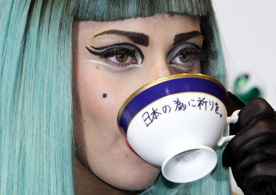 Lady Gaga holds a teacup with the words quotPray for Japanquot written on it as she attends a news conference in Tokyo.