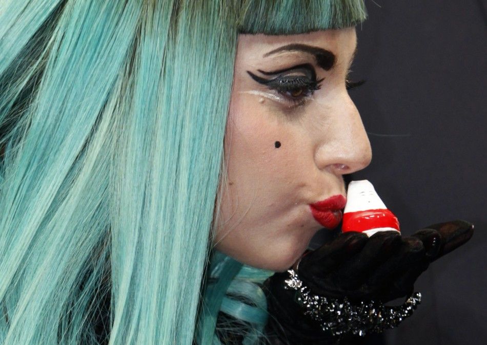 U.S. singer Lady Gaga kisses a Okiagari-koboshi doll in Tokyo