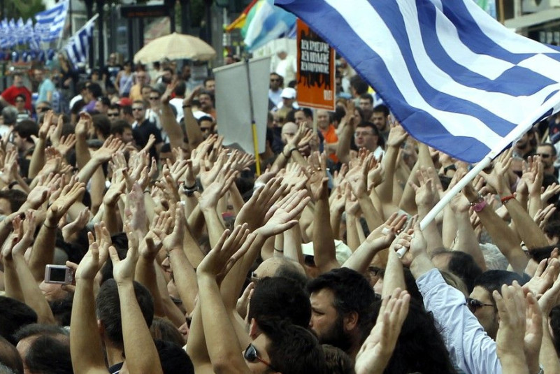 Demonstrators wave flags near the Greek parliament in Athens