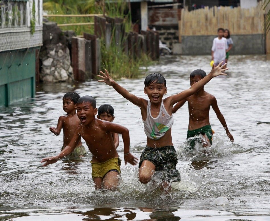 Children play in a flooded residential area in Malabon