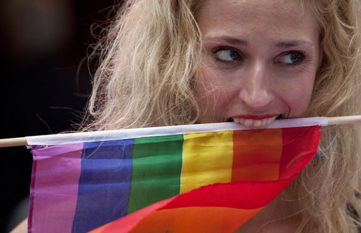 A protester clenches a rainbow flag with her teeth at a demonstration outside Sheraton Hotel where U.S. President Obama was attending a function in New York.