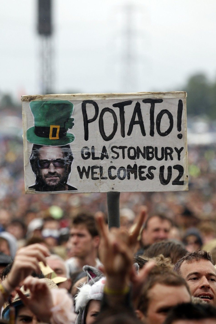 A festival goer holds a placard protesting against Irish group U2
